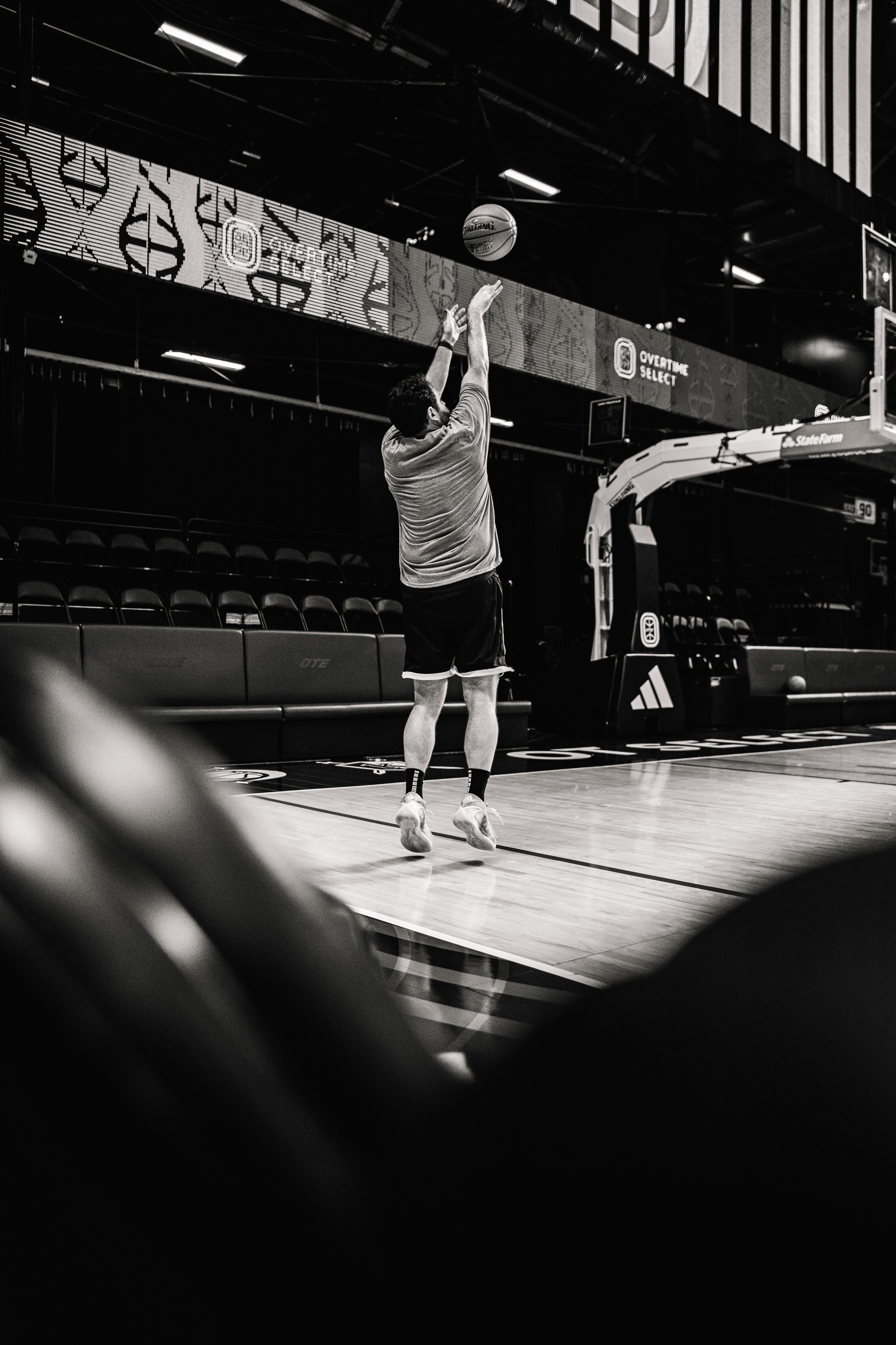 Hooper spinning a basketball on a fingertip in a dark gym